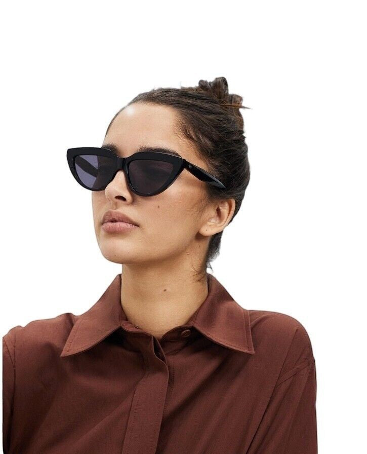 Model wearing Naked Pear Karen Walker Lash Splash black bio-acetate cat-eye sunglasses with grey mono lenses
