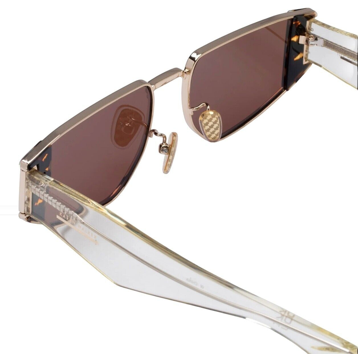 Naked Pear Karen Walker Nix sunglasses with geometric metal frames, clear acetate temples, and brown mono lenses.