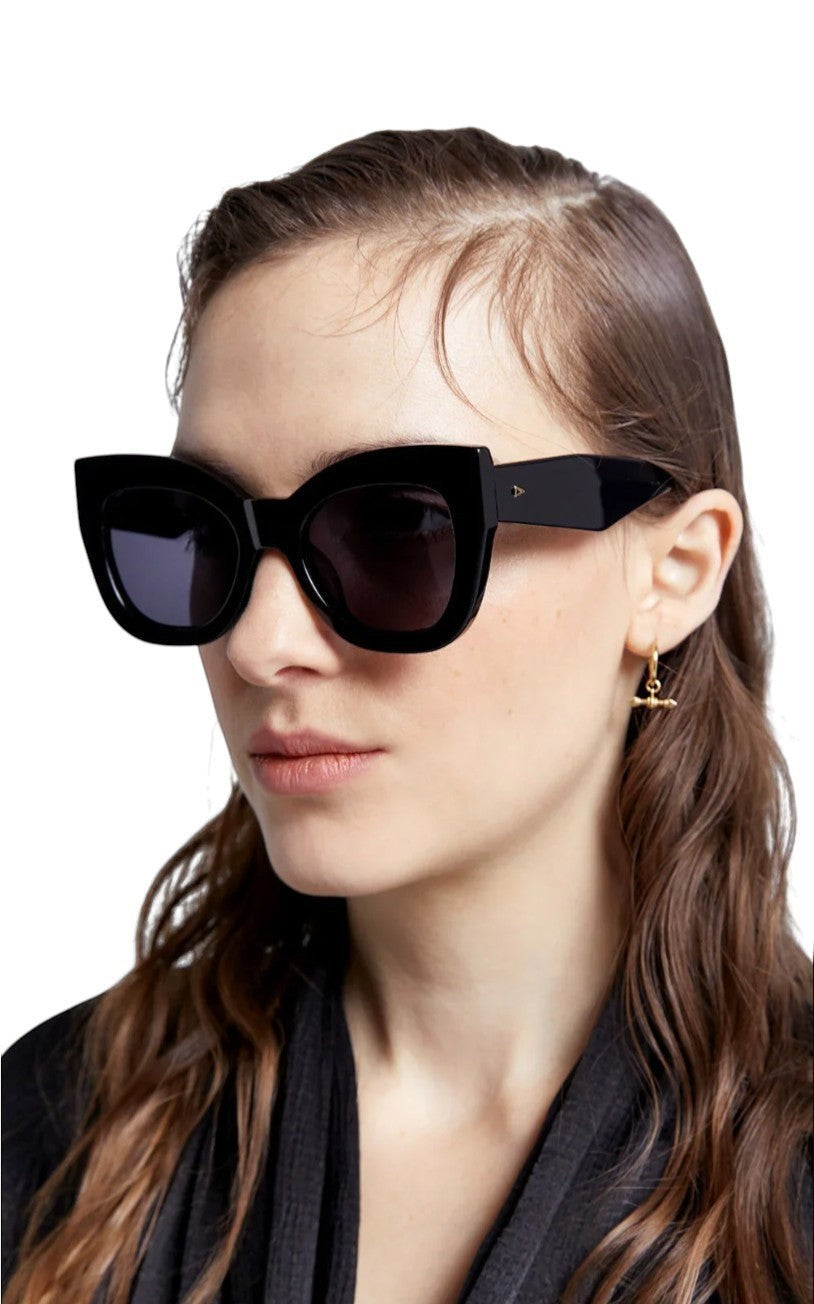 Model wearing Naked Pear Karen Walker Northern Lights oversized black cat-eye sunglasses with grey lenses