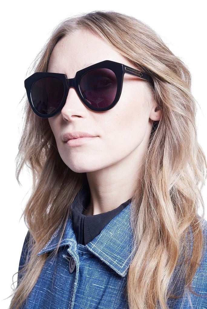 Model wearing Naked Pear Karen Walker Number One black bio-acetate cat-eye sunglasses with grey smoke mono lenses
