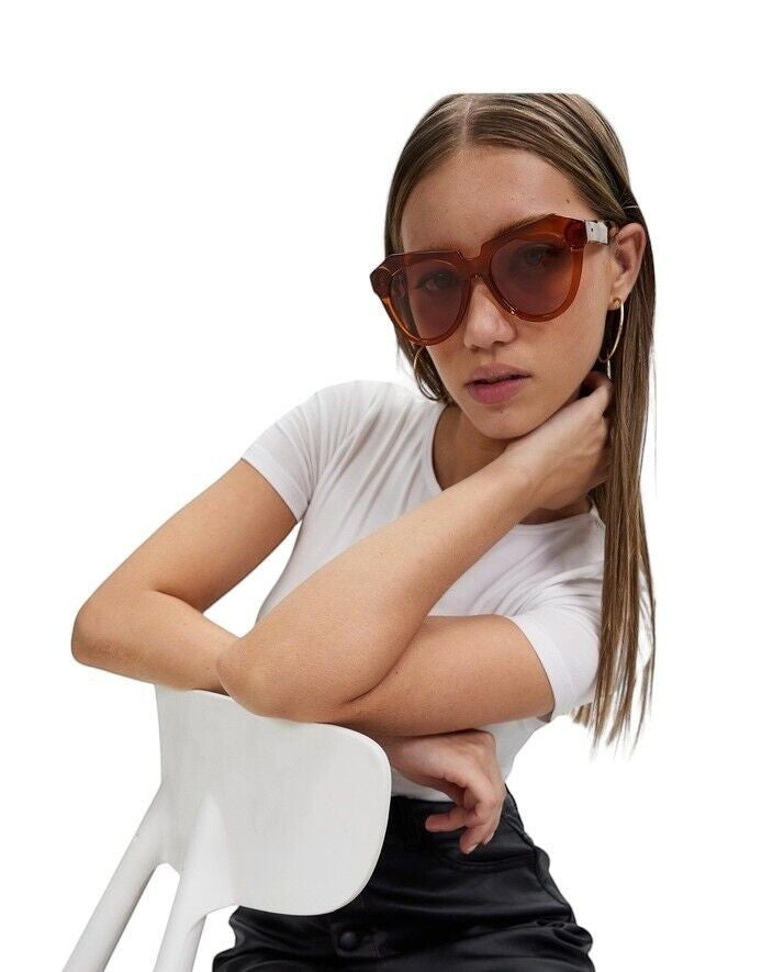 Model wearing Naked Pear Karen Walker Number One oversized cat-eye sunglasses in persimmon and tortoise shell acetate