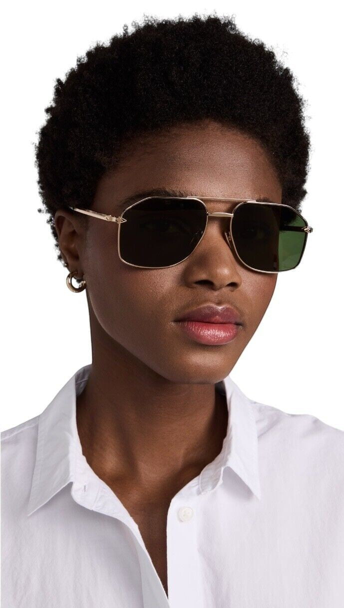 Model wearing Naked Pear Karen Walker Pampel aviator sunglasses with polished gold frames and grass-green lenses.