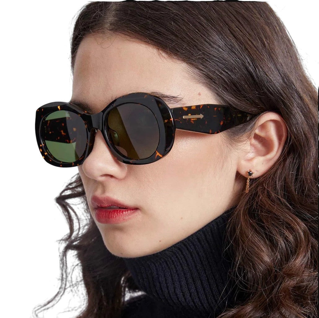 Model wearing Naked Pear Karen Walker Parlour oversized oval sunglasses in cracked tortoise shell with green lenses