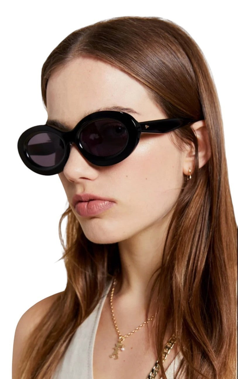 Naked Pear Karen Walker Rapture B oval sunglasses in black bio-acetate with grey lenses worn by a woman