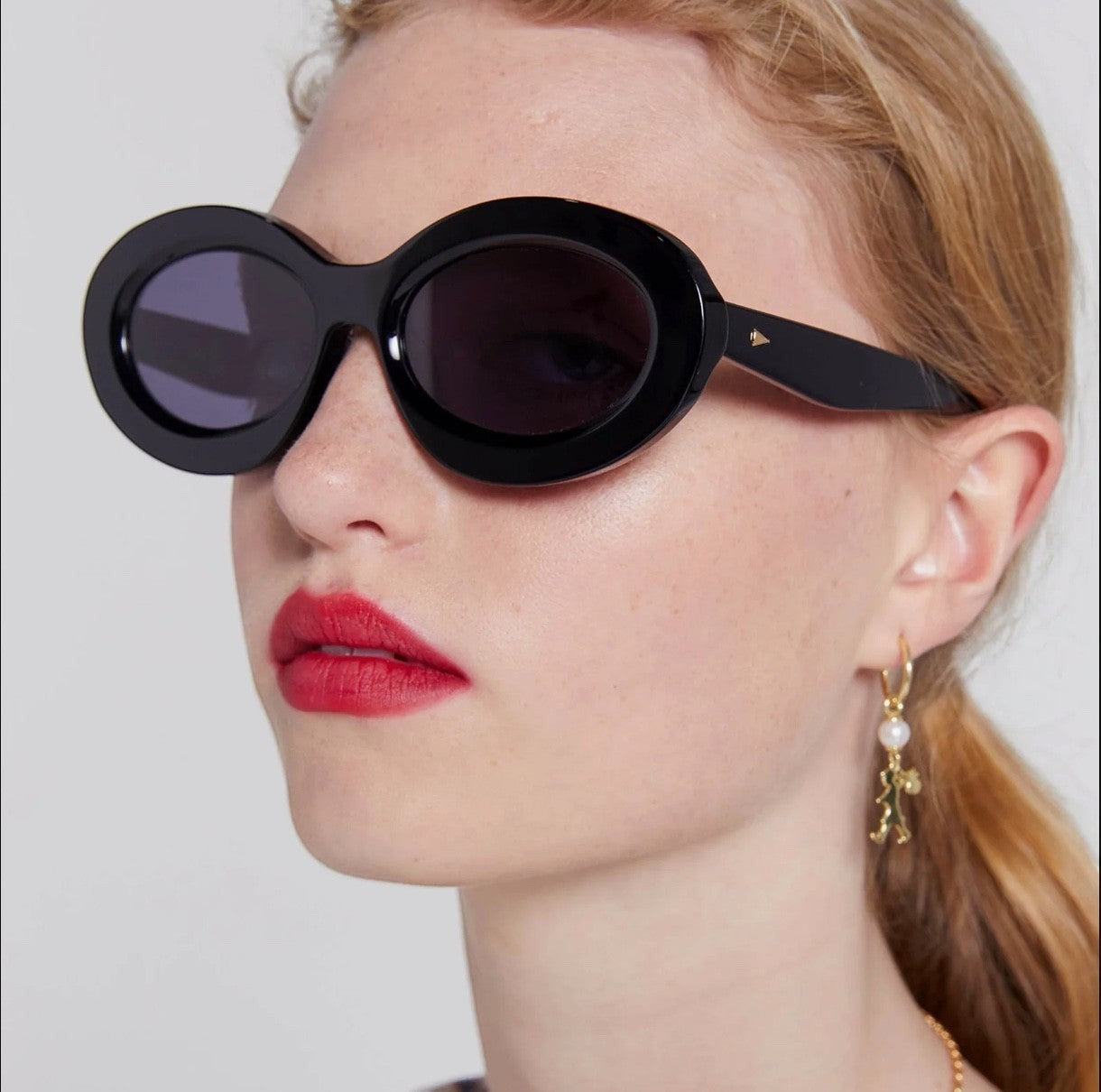 Naked Pear Karen Walker Rapture B oversized oval black bio-acetate sunglasses with grey lenses worn by a model
