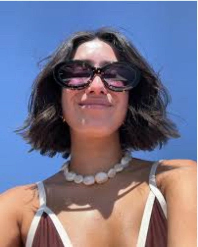 Naked Pear model wearing Karen Walker Rapture B oval sunglasses in cracked tortoise shell with grey lenses
