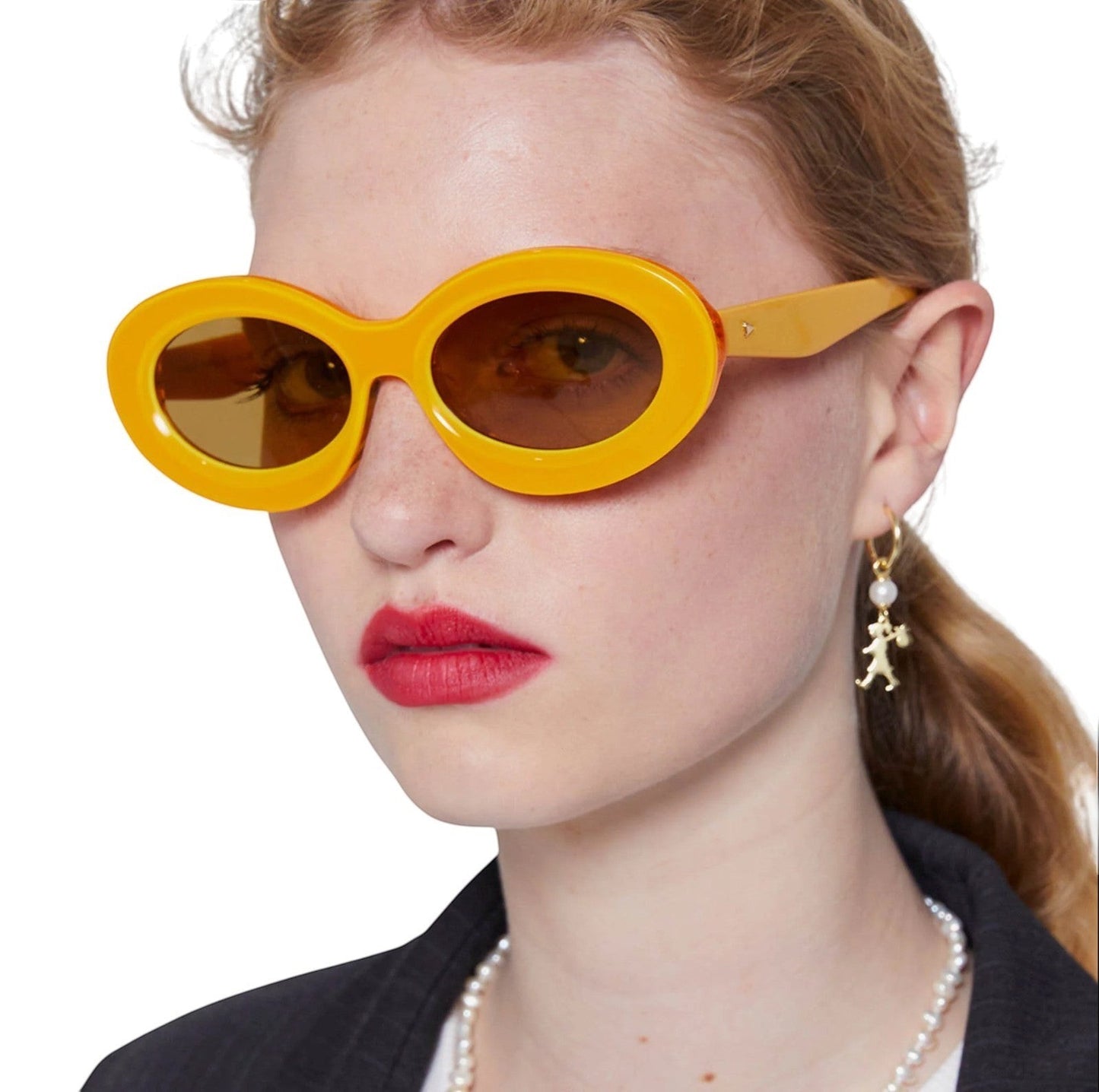 Naked Pear Karen Walker Rapture B oval sunglasses in marigold yellow bio-acetate with brown mono lenses on a model.