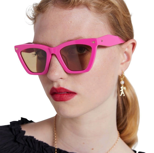 Naked Pear Karen Walker Spellbound cat-eye sunglasses in fuchsia acetate with brown lenses worn by a model