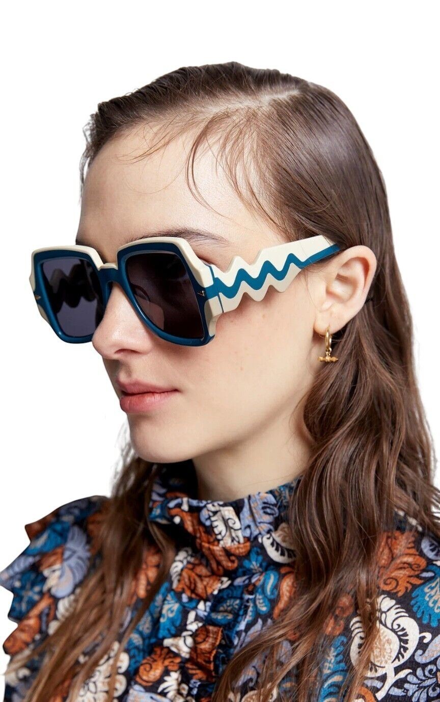 Naked Pear Karen Walker Wavy Ultra B sunglasses with blue and white wavy frames and dark grey lenses.