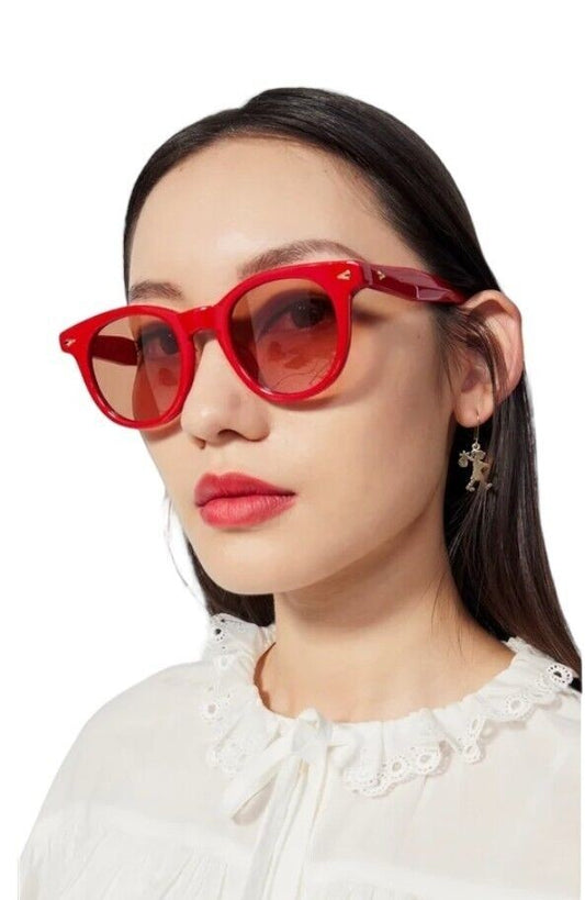 Model wearing Naked Pear Karen Walker Wilderness round scarlet red acetate sunglasses with persimmon tint lenses