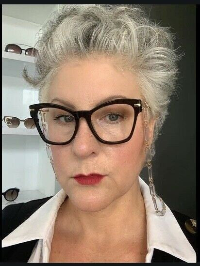 Woman wearing Naked Pear Karen Walker Wilma oversized black acetate cat eye glasses with gold arrow temple detail