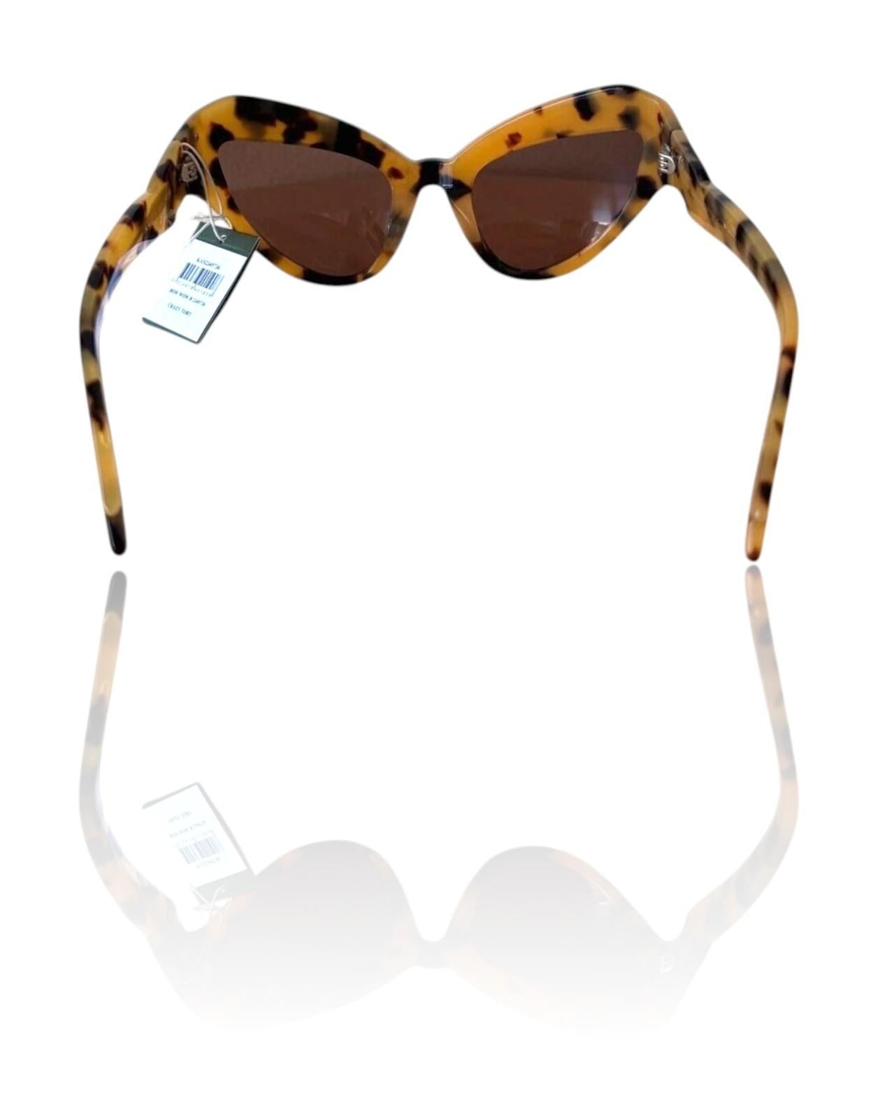 Sunglasses with tortoiseshell frame and brown lenses on a white background