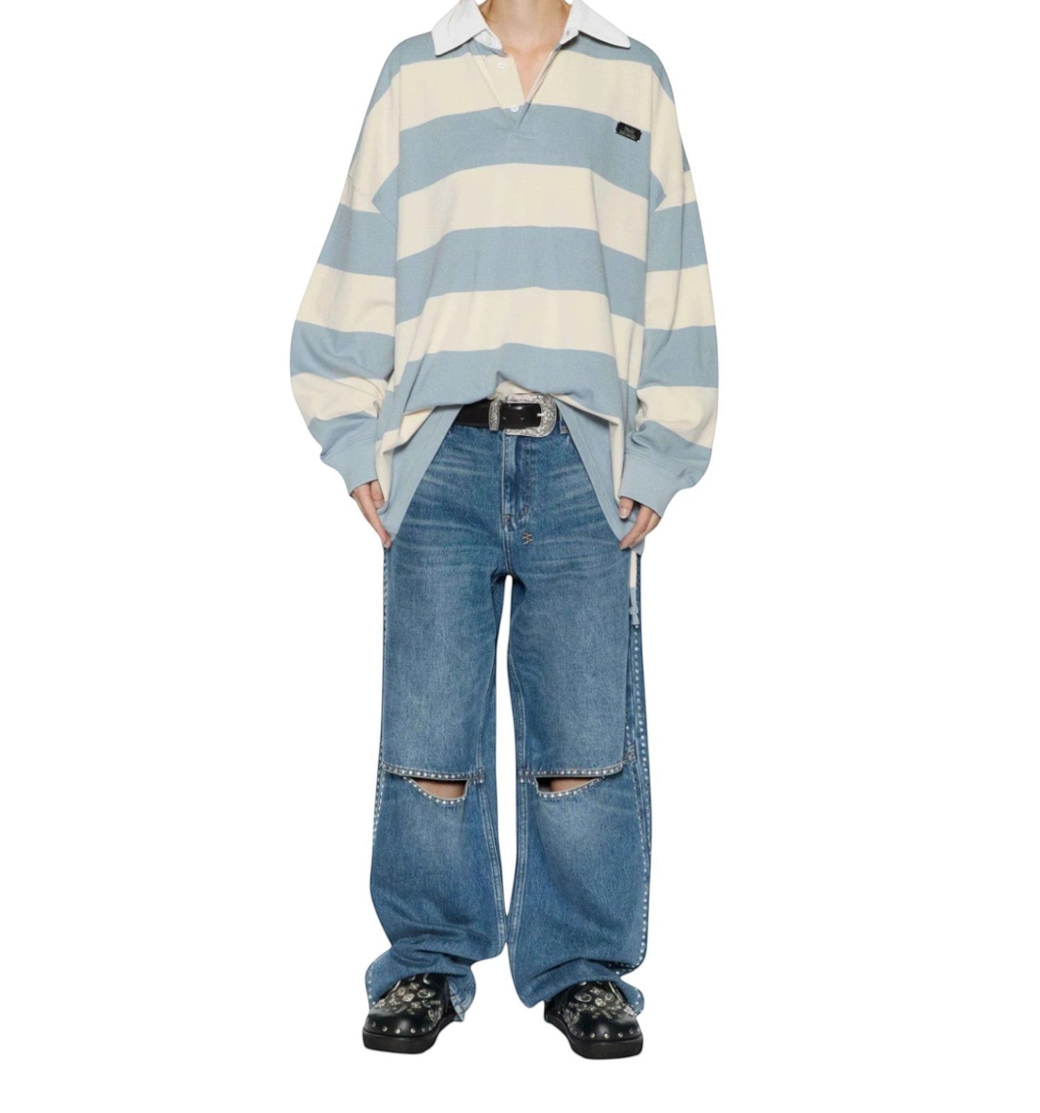 Naked Pear model wearing Ksubi Low Rider blue denim jeans with knee cutouts and silver studs, paired with a rugby top