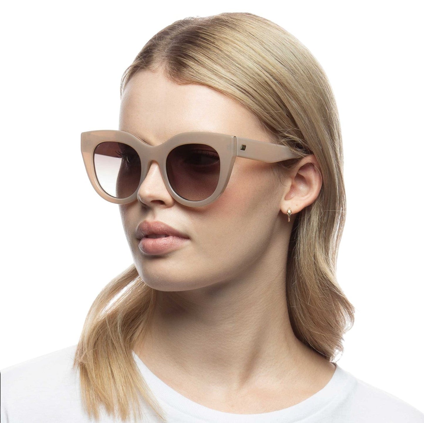 Model wearing Naked Pear Le Specs Air Heart cat eye sunglasses in oatmeal acetate with khaki gradient lenses