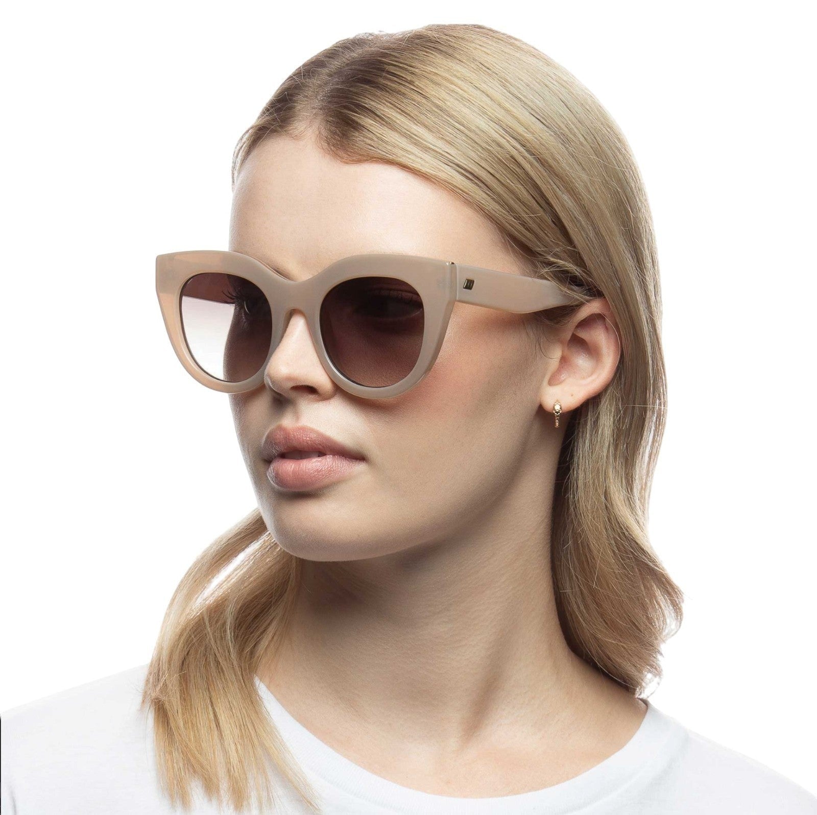Model wearing Naked Pear Le Specs Air Heart cat eye sunglasses in oatmeal acetate with khaki gradient lenses