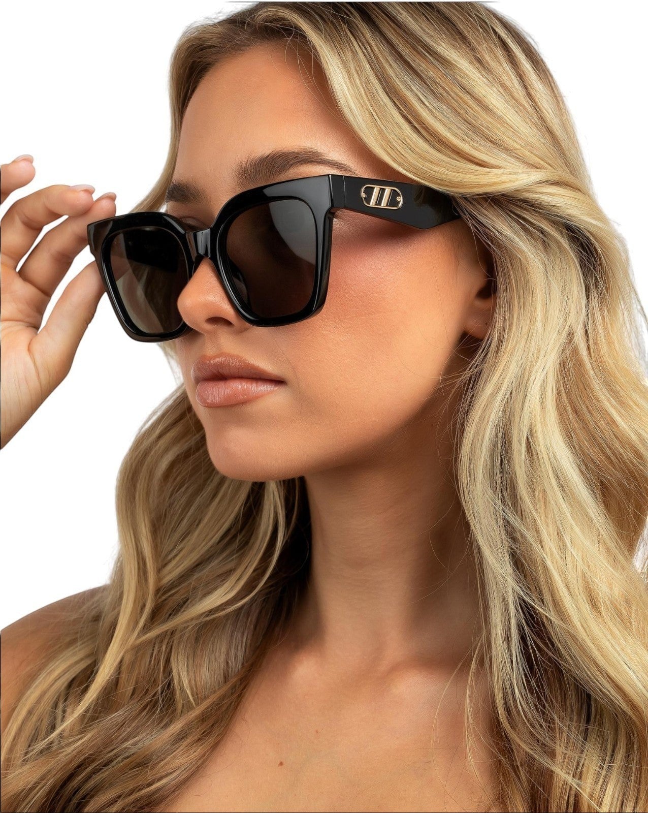 Naked Pear Le Specs Star Glow black oversized cat-eye sunglasses with gold chain link temple detail on a blonde model