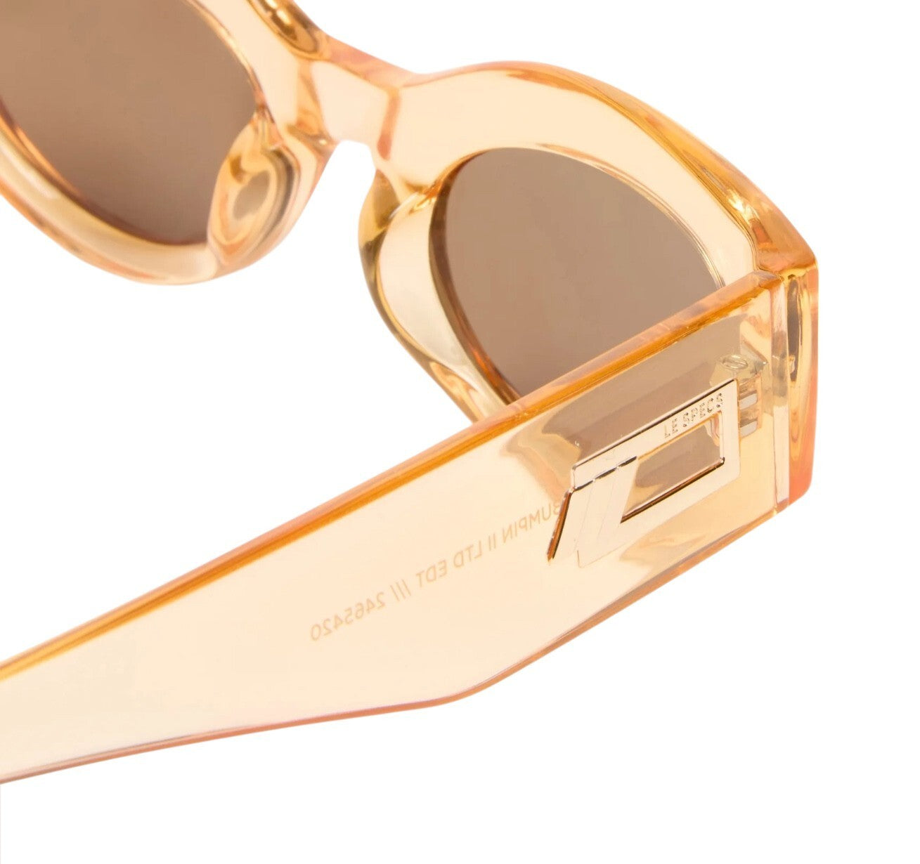 Close-up of a pair of sunglasses with a gold frame on a white background