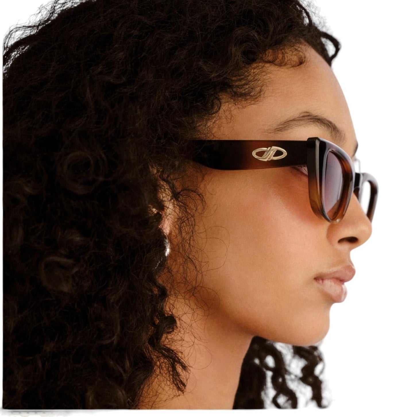 Close-up of a person wearing sunglasses with a brand logo.