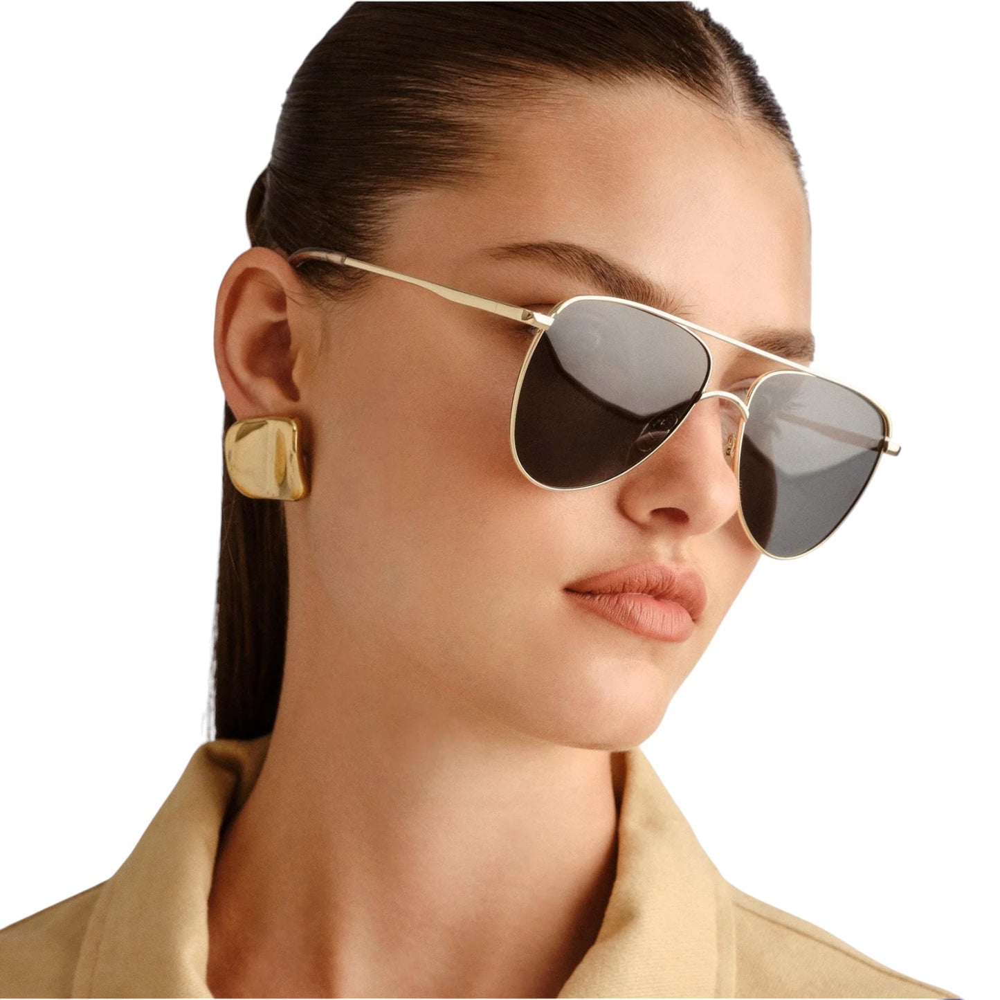 Woman wearing gold aviator sunglasses with a neutral background