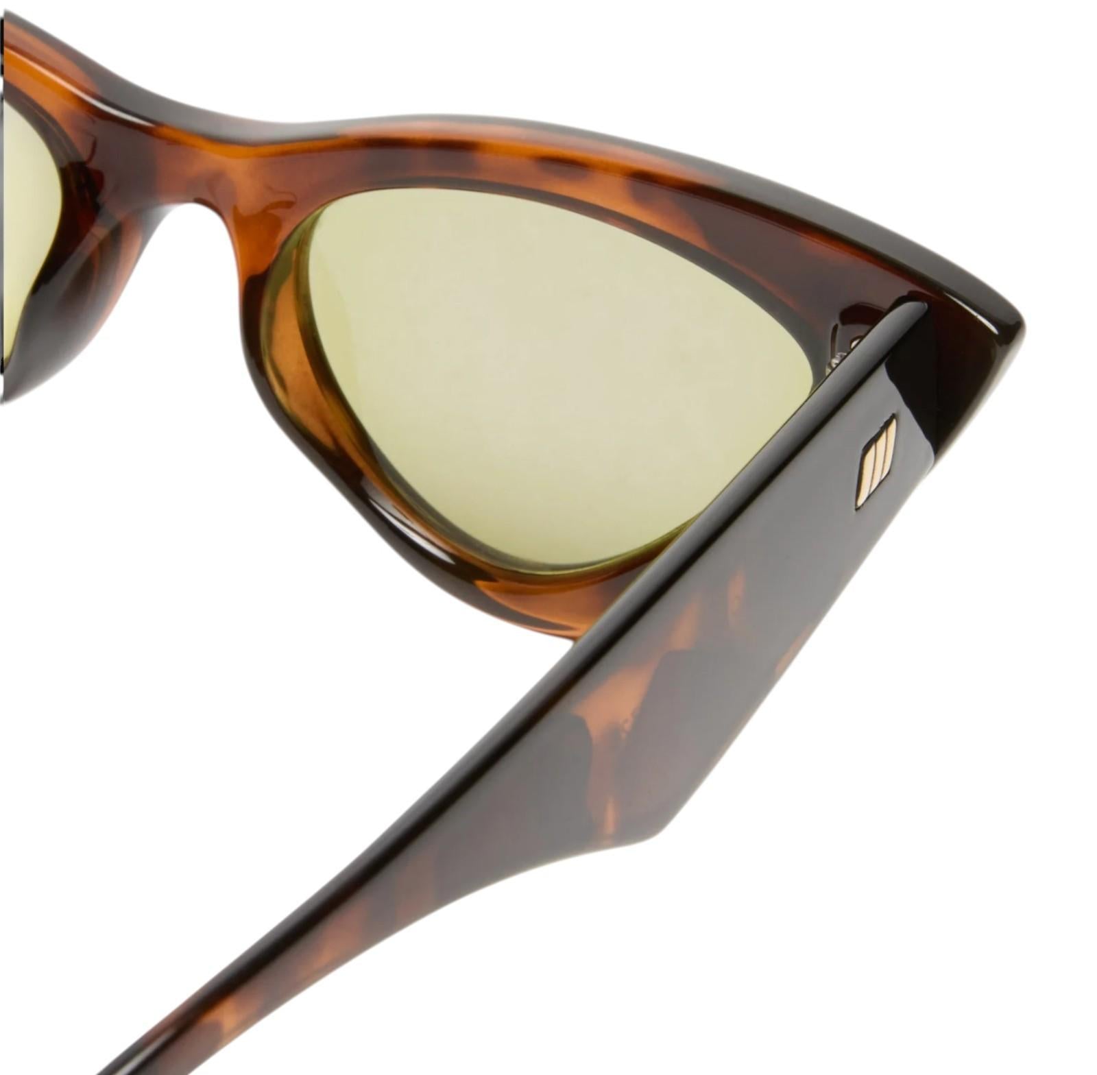 Tortoiseshell sunglasses with gold lenses on a white background