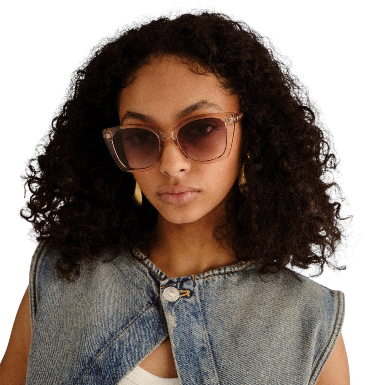 Woman wearing sunglasses and a denim vest on a white background