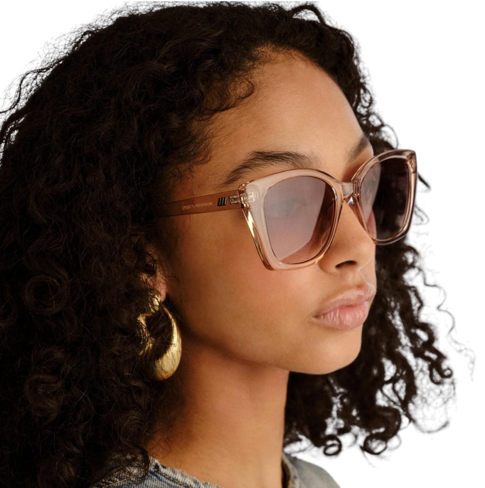 Person wearing sunglasses with a neutral background