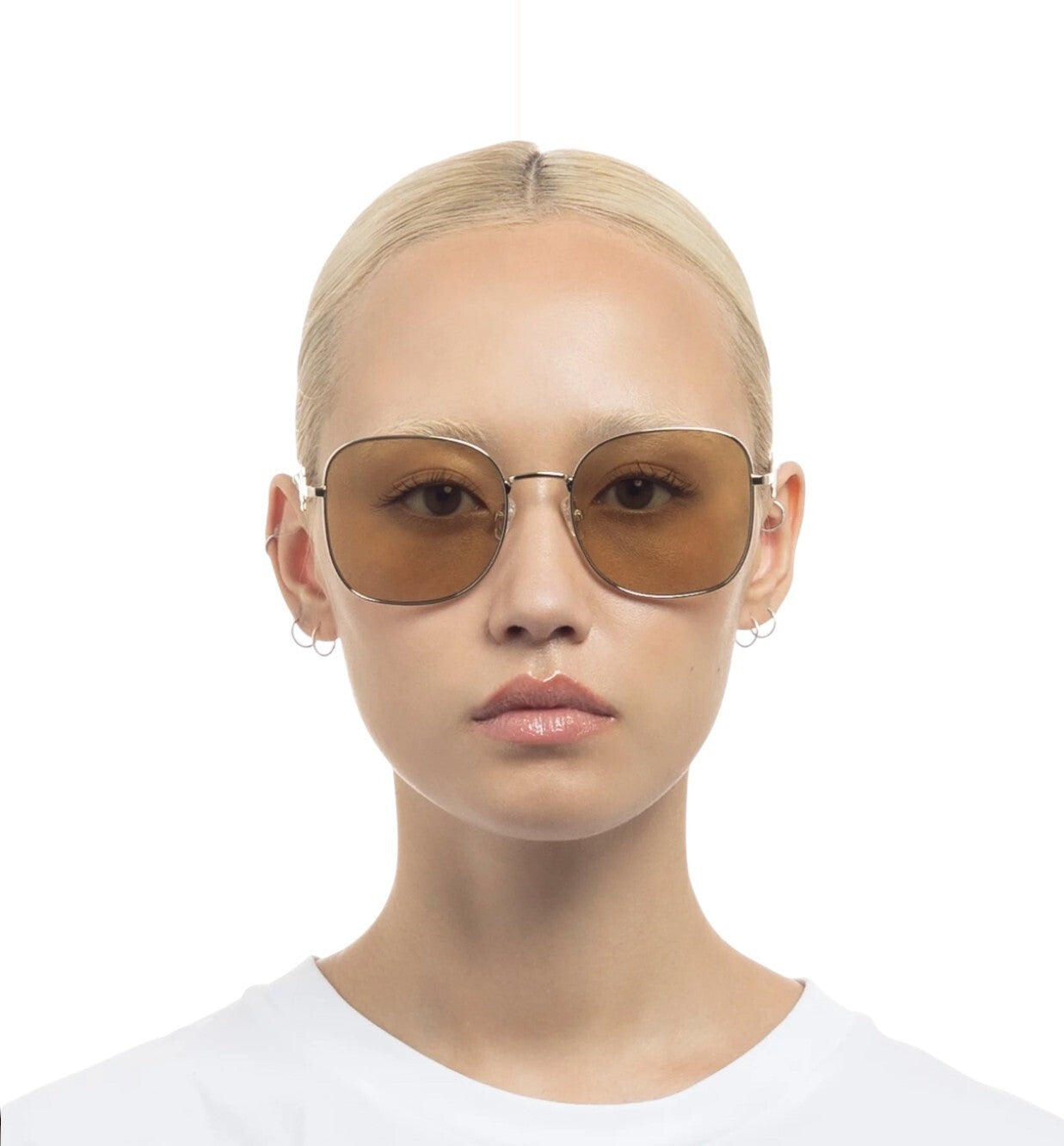 Person wearing brown sunglasses on a white background