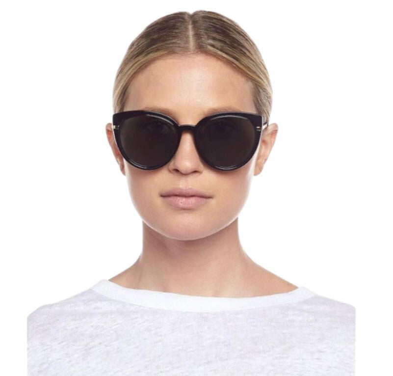 Woman wearing black sunglasses on a white background