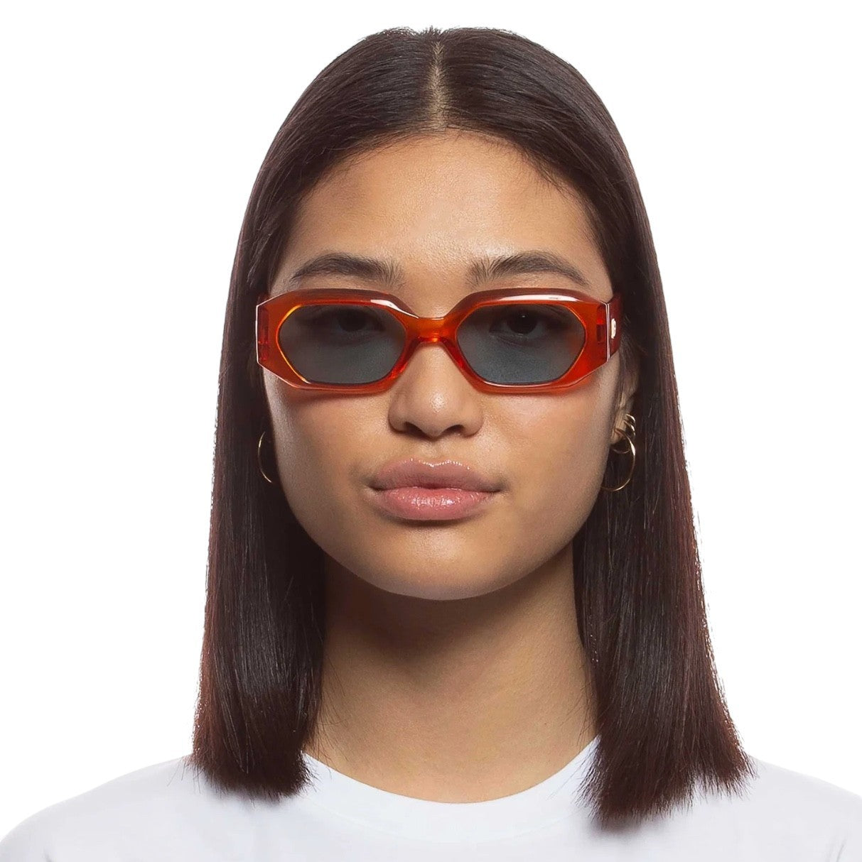 Person wearing red sunglasses with a plain background