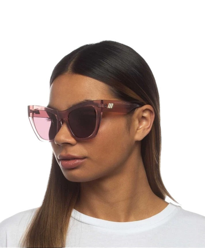 Woman wearing a pair of sunglasses with a white background