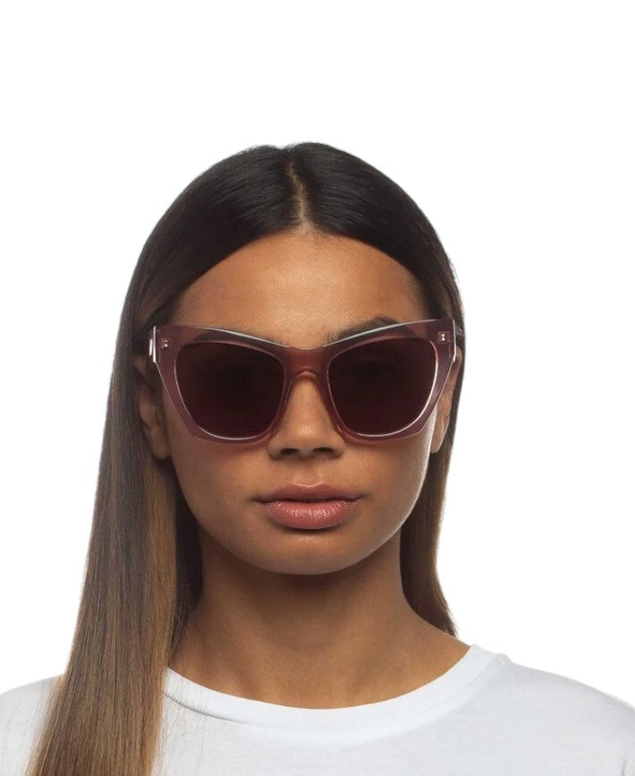 Woman wearing a pair of sunglasses with a white background