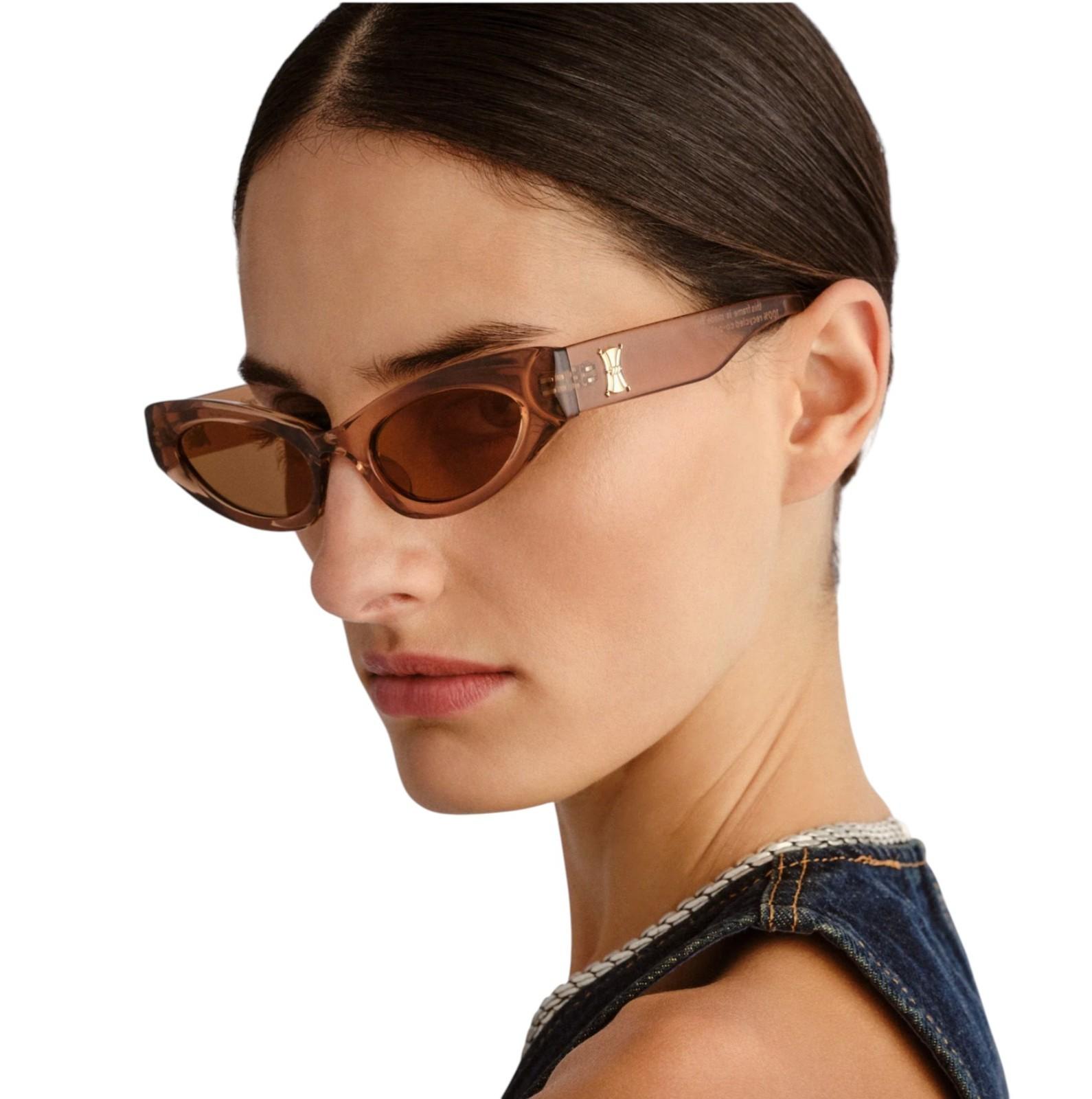 Woman wearing brown sunglasses with a white background