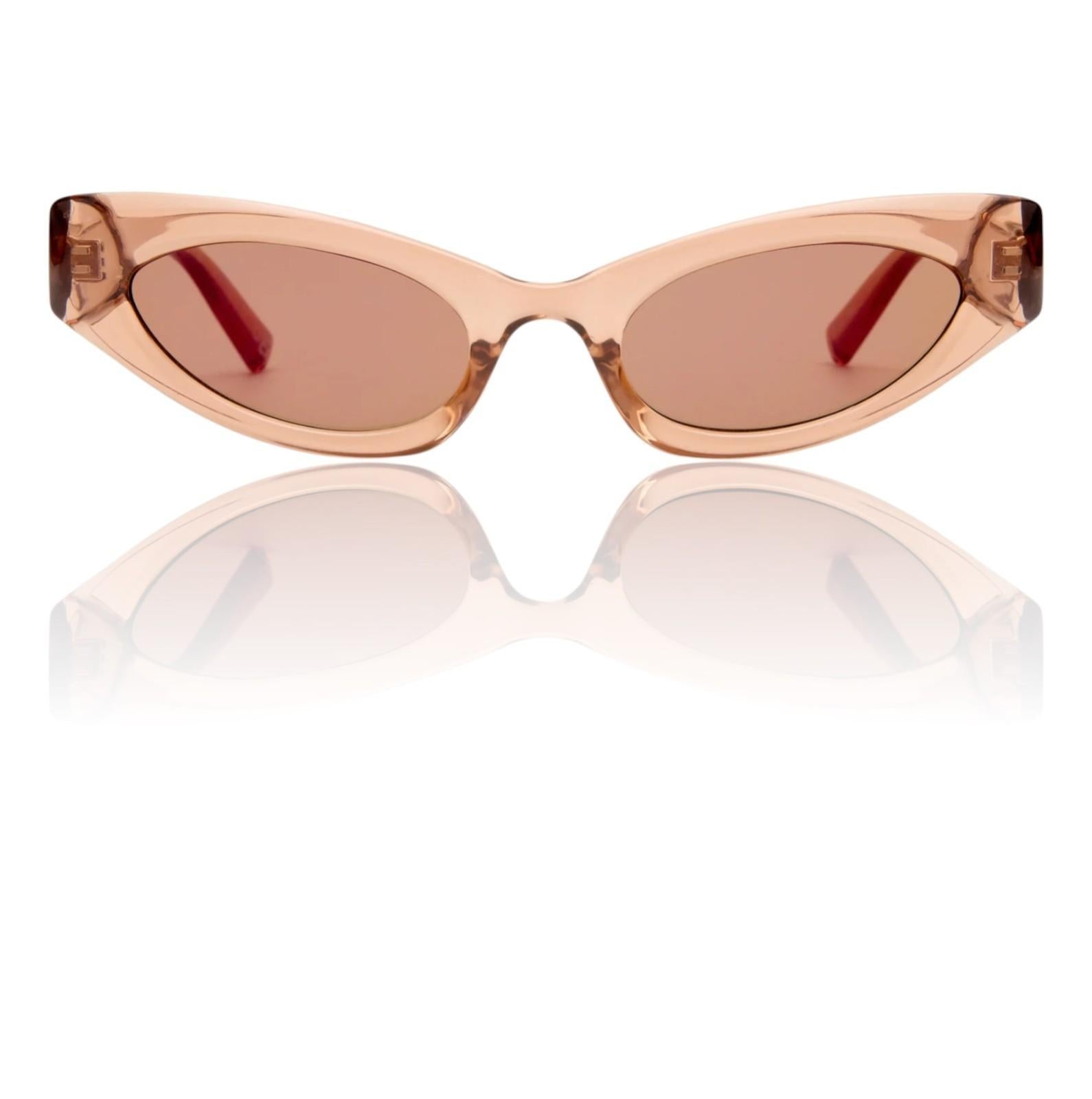 Cat-eye sunglasses with a transparent peach frame and brown lenses on a white background