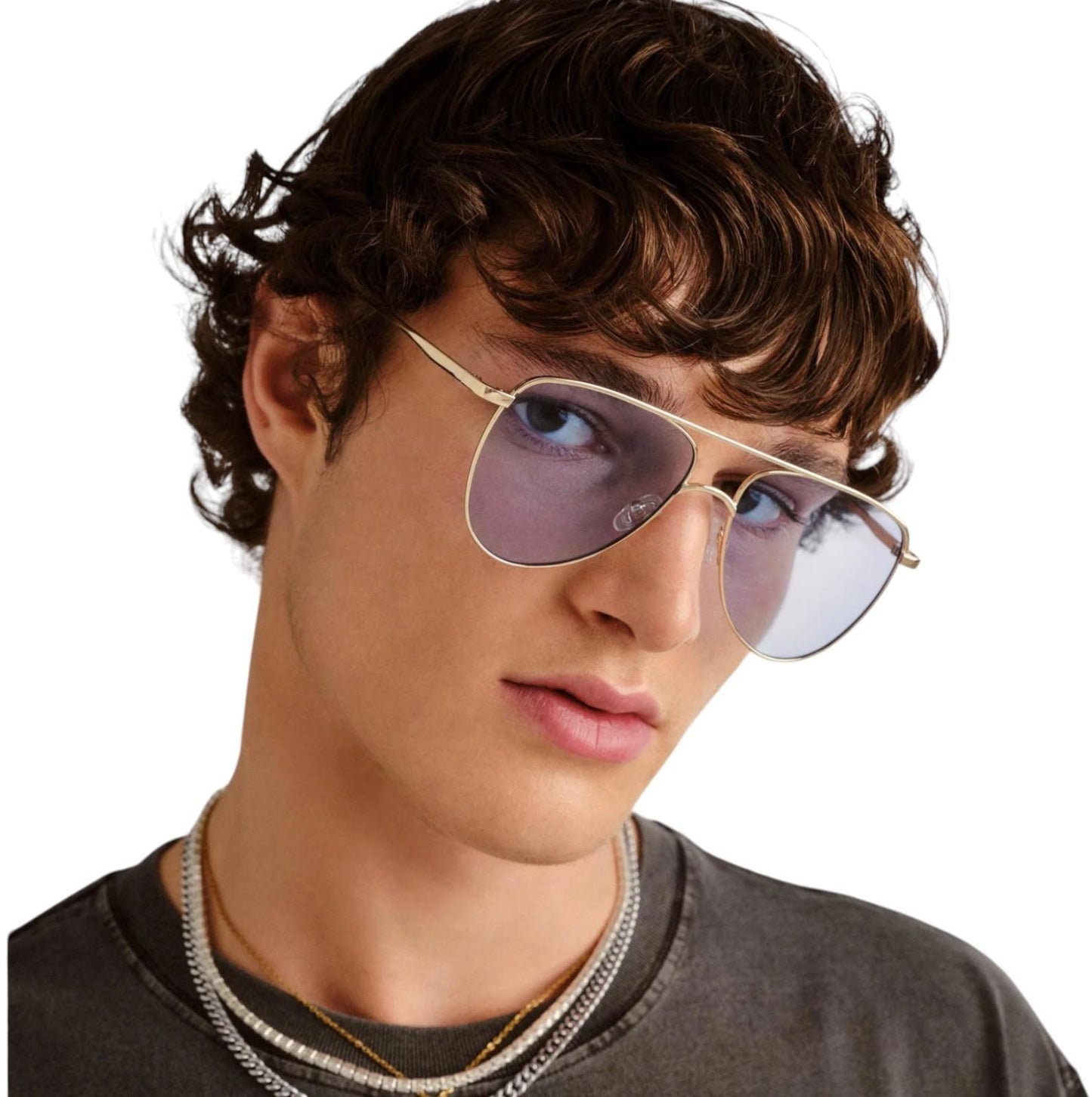 Person wearing gold-framed sunglasses with a neutral background