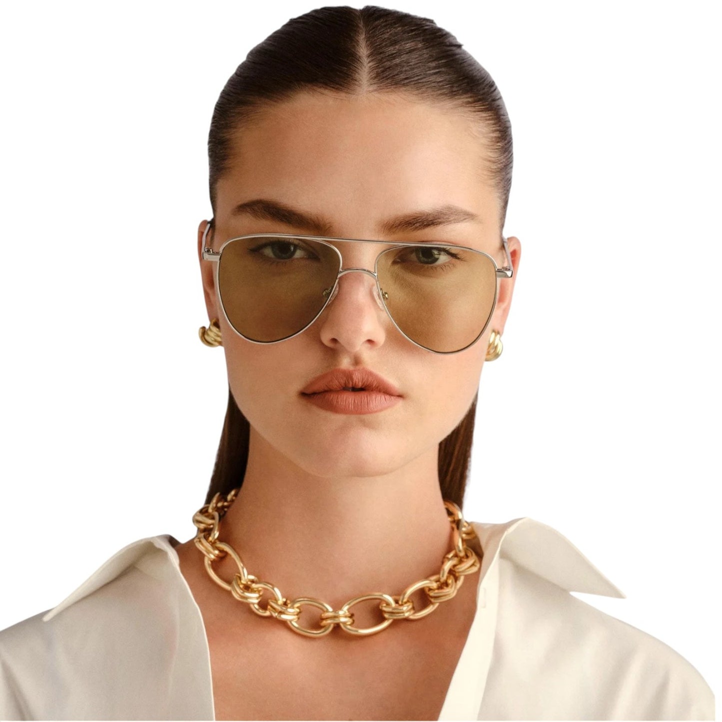 Woman wearing gold chain necklace and sunglasses on a white background