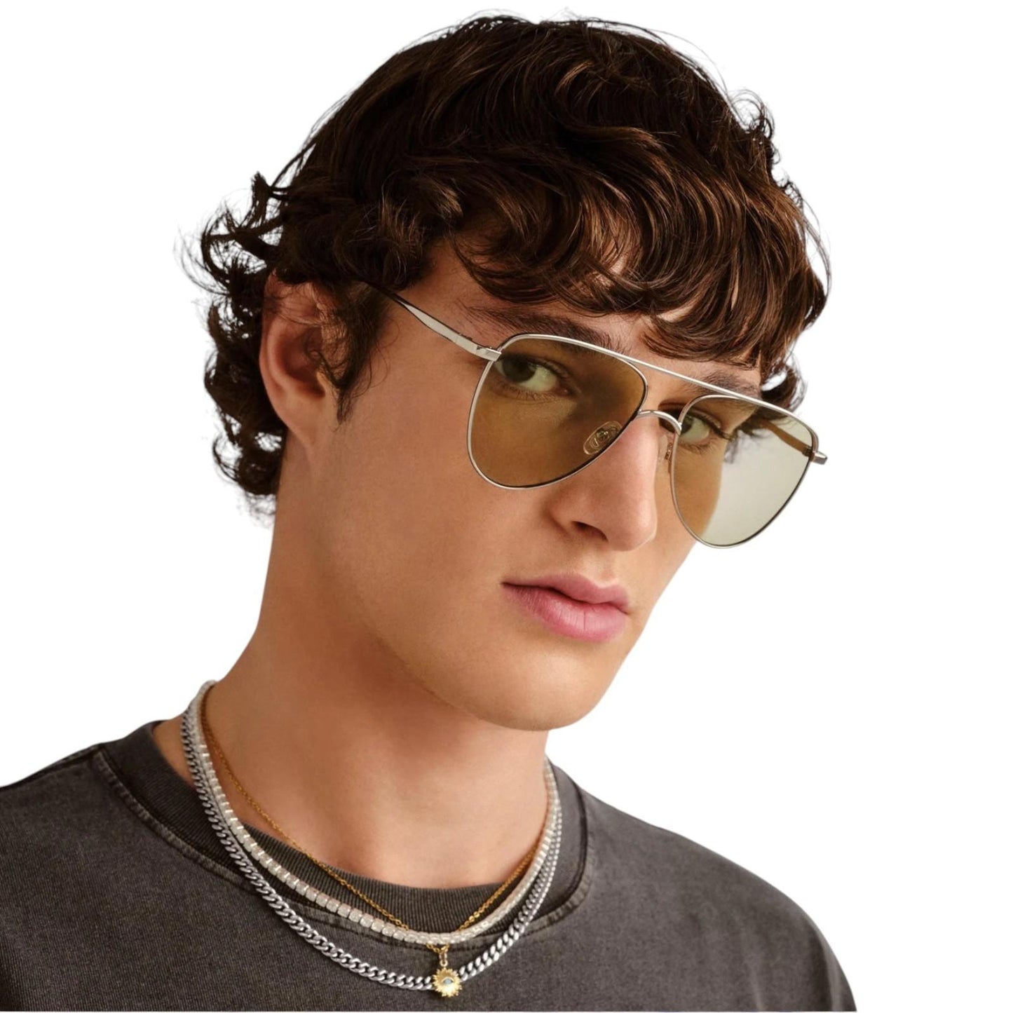 Person wearing gold aviator sunglasses with a neutral background