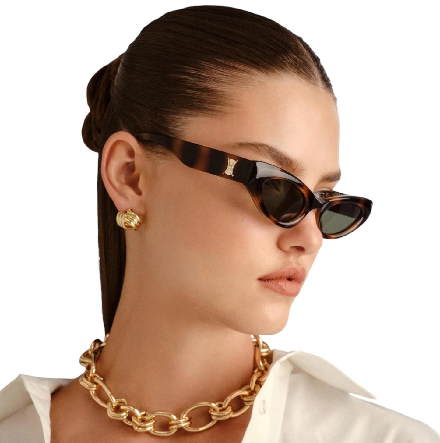 Woman wearing tortoiseshell sunglasses and a gold chain necklace on a white background