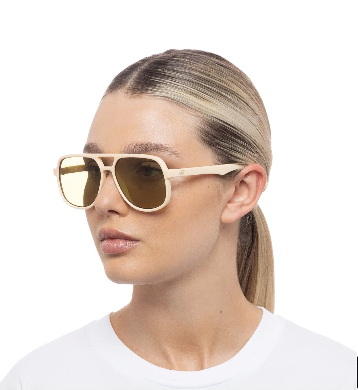 Woman wearing gold sunglasses with a white background