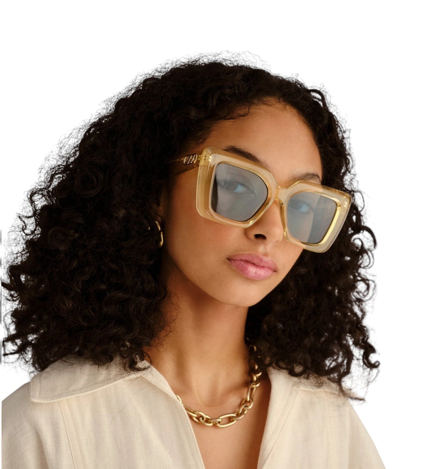 Woman wearing gold-framed sunglasses with a plain background