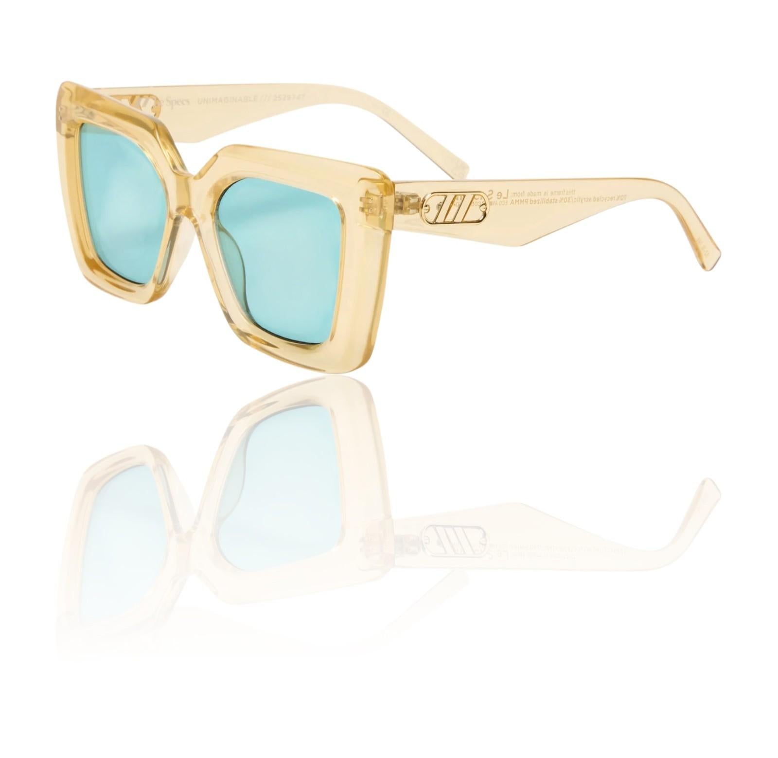 Gold-framed sunglasses with blue lenses on a white background
