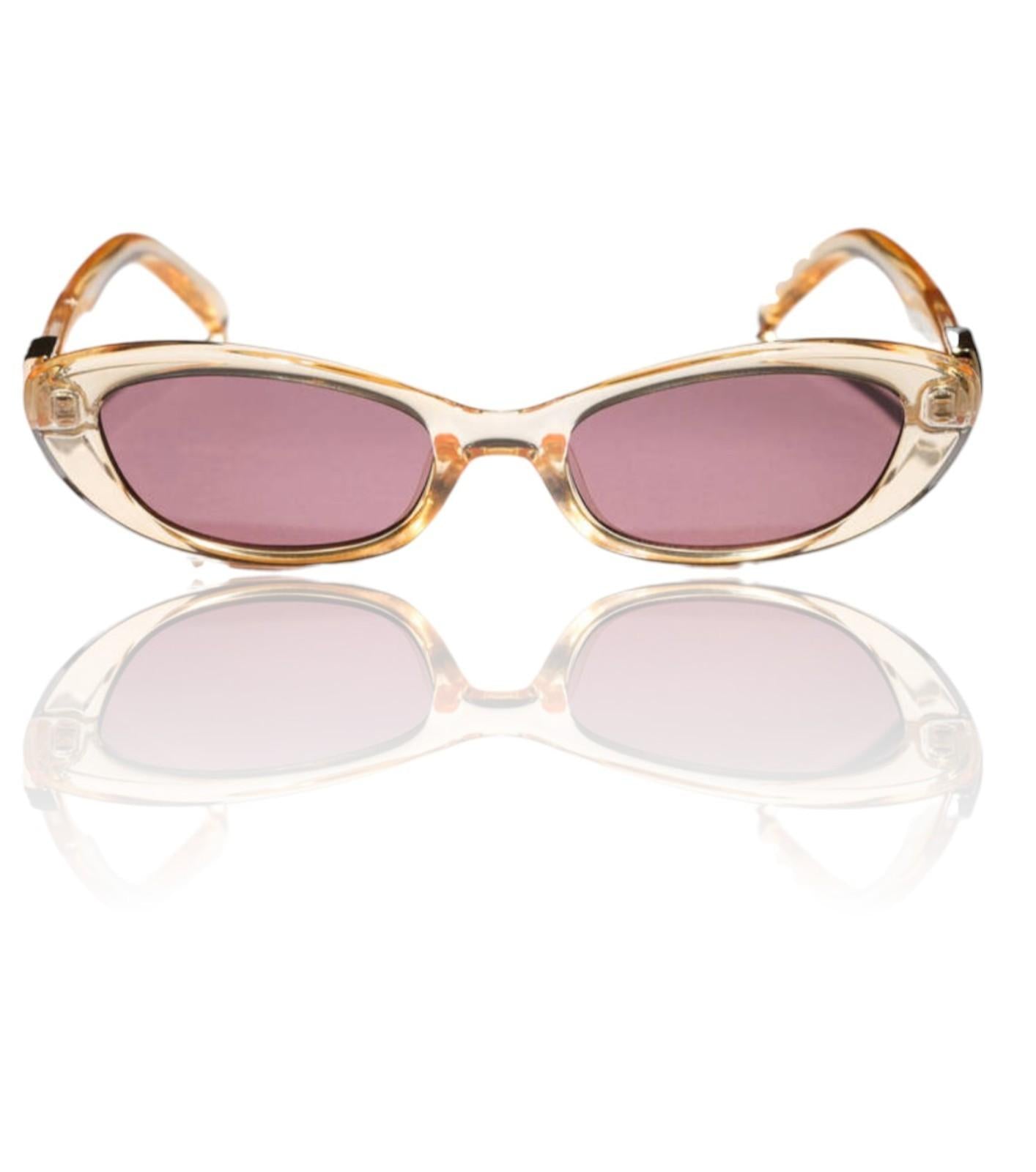 Sunglasses with gold frame and pink lenses on a white background