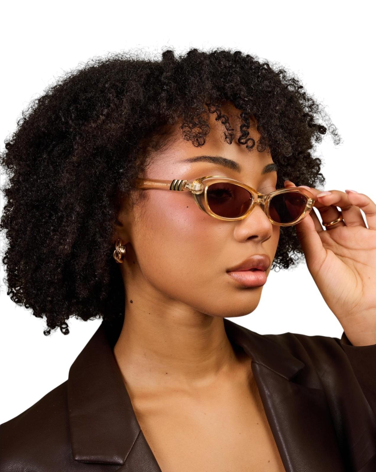 Woman wearing sunglasses with a plain background