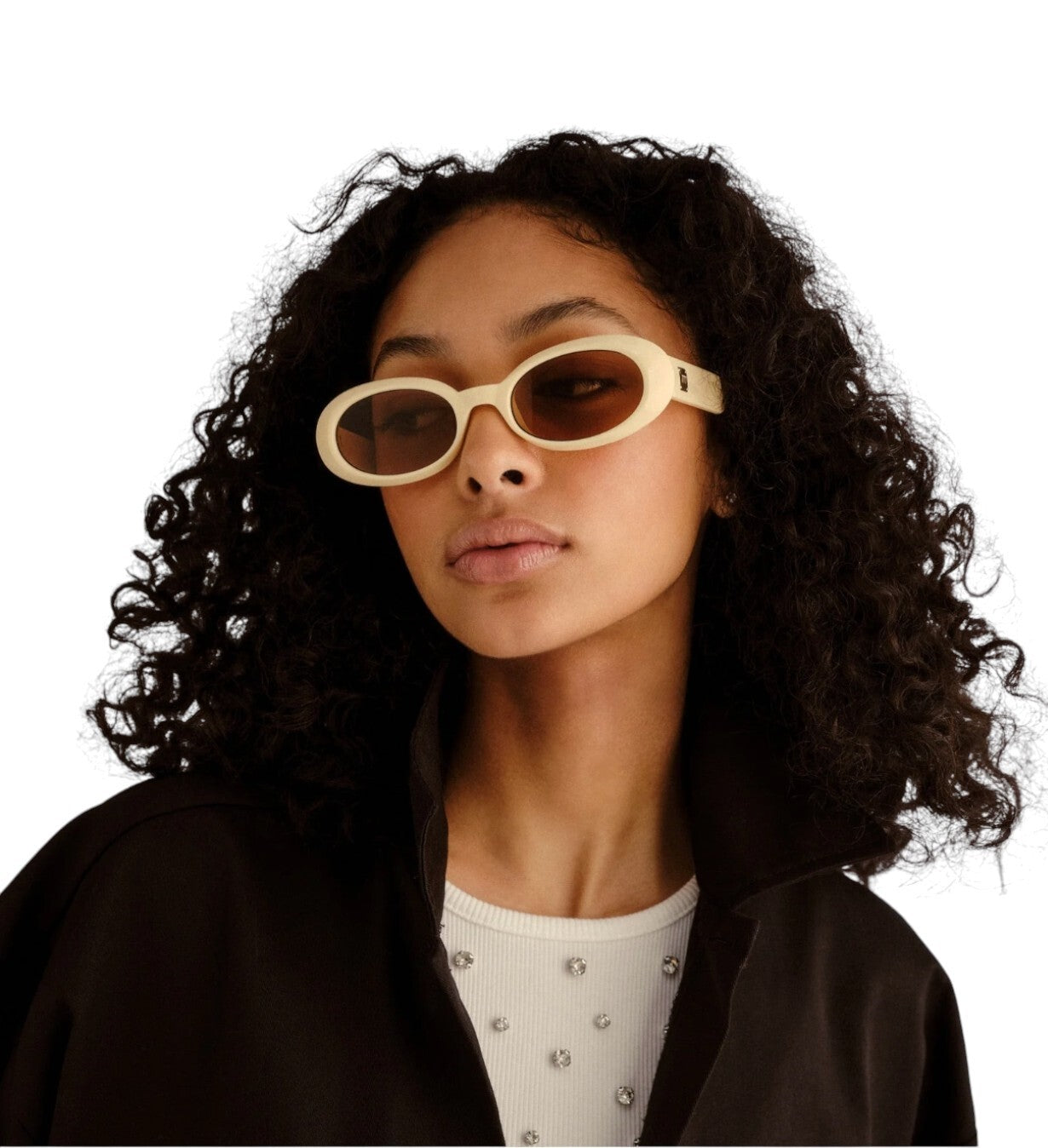 Person wearing gold sunglasses with a plain background