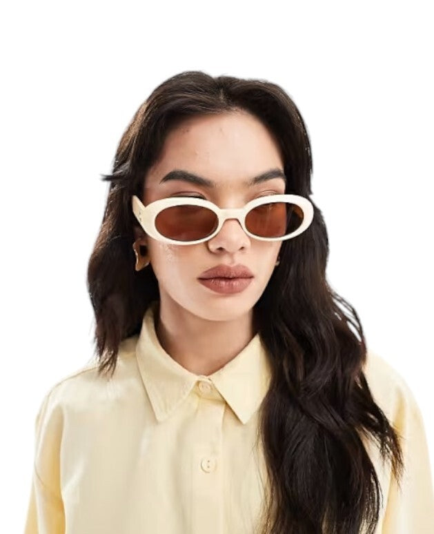 Woman wearing a yellow shirt and sunglasses with a plain background