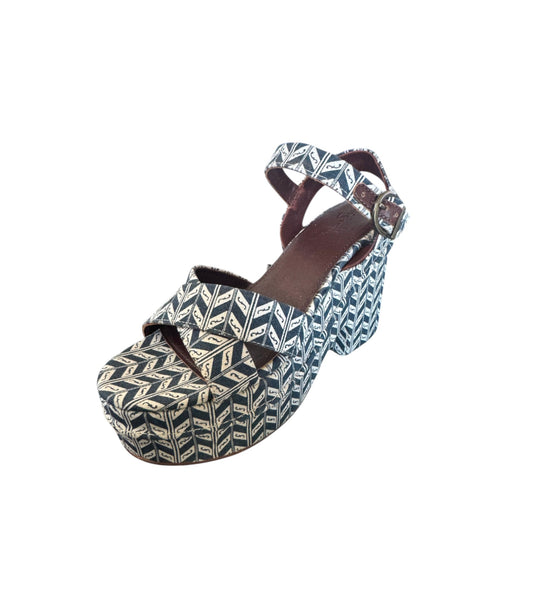 A single women's platform sandal with a navy blue and beige geometric chevron pattern, featuring a brown leather ankle strap and a low block heel, shown on a plain white background.