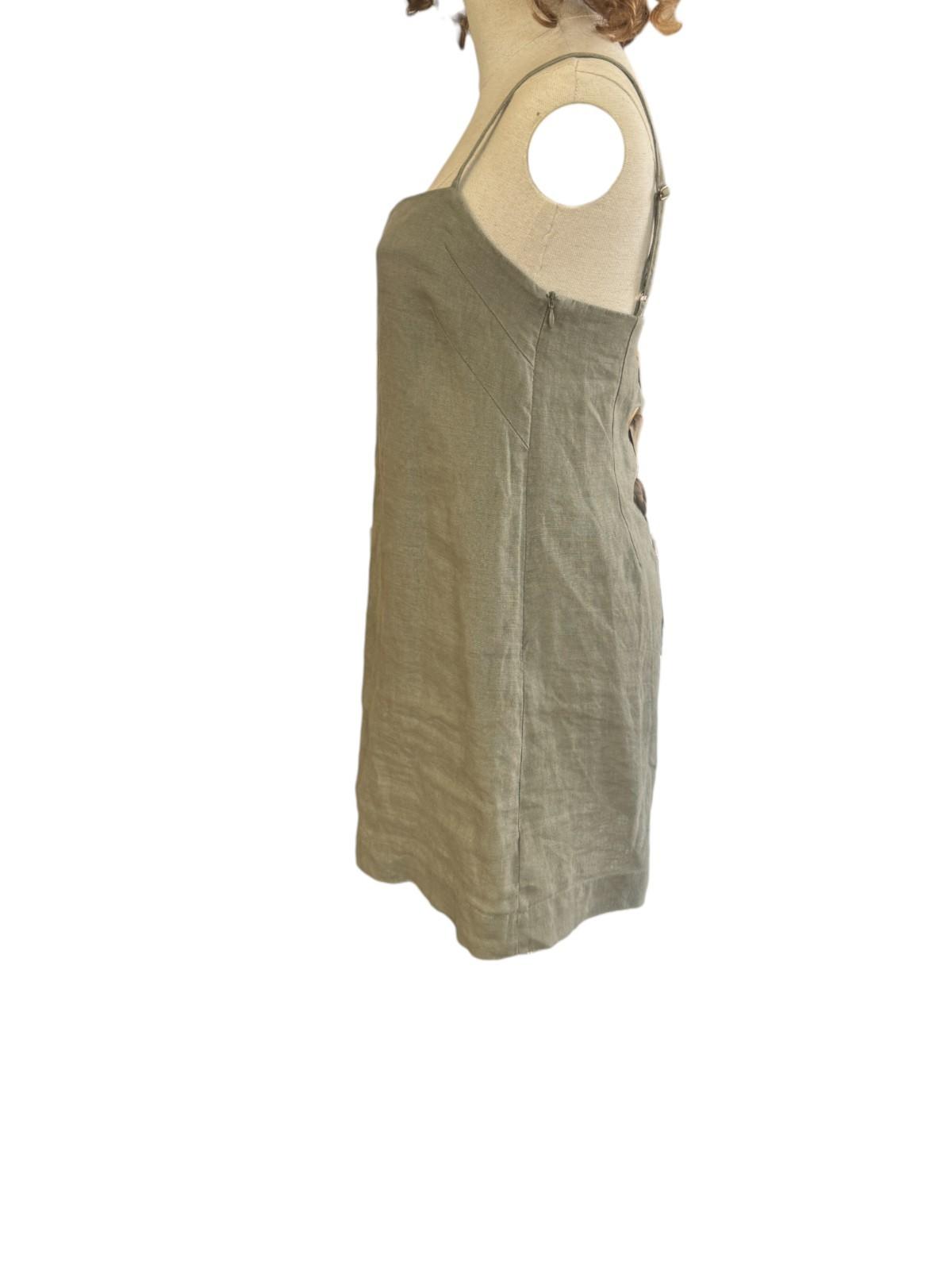 Green sleeveless dress on a mannequin against a white background