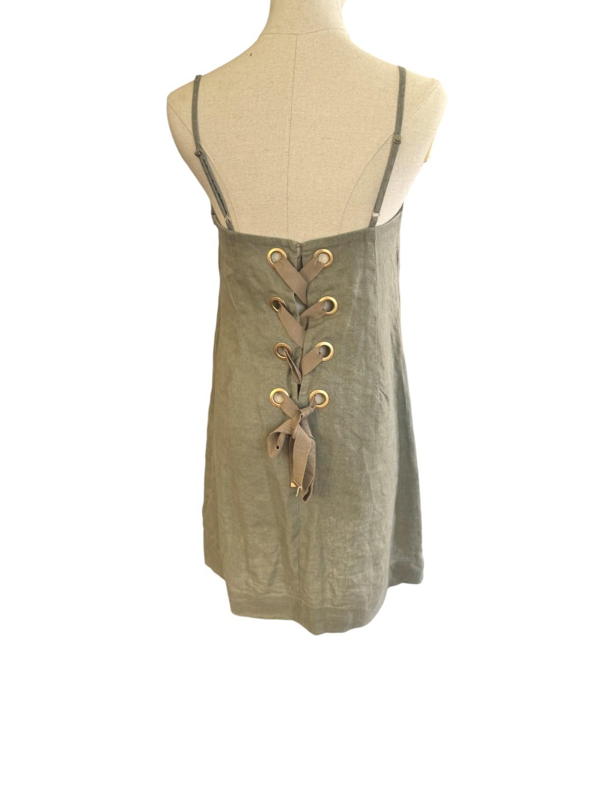 Green lace-up dress on a mannequin against a white background