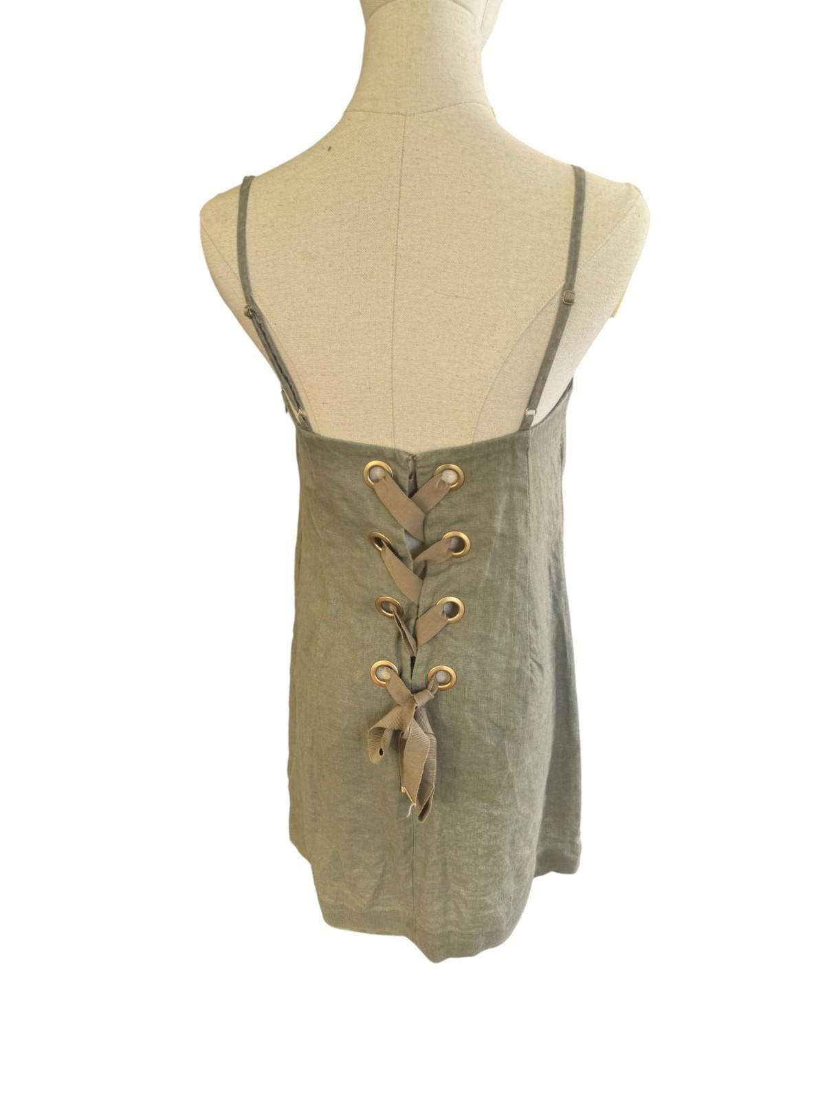 Green lace-up dress on a mannequin against a white background