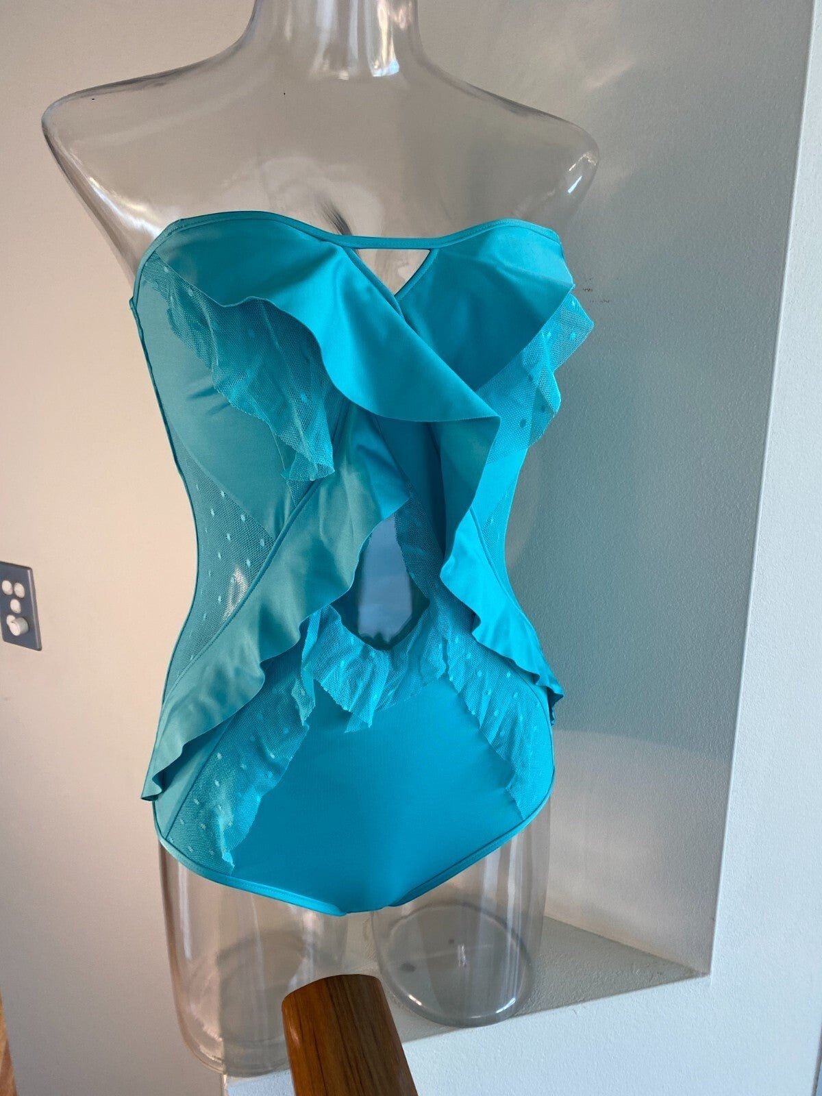 Naked Pear Zimmermann Peggy turquoise one-piece swimsuit with bandeau silhouette, mesh inserts, and ruffle details.