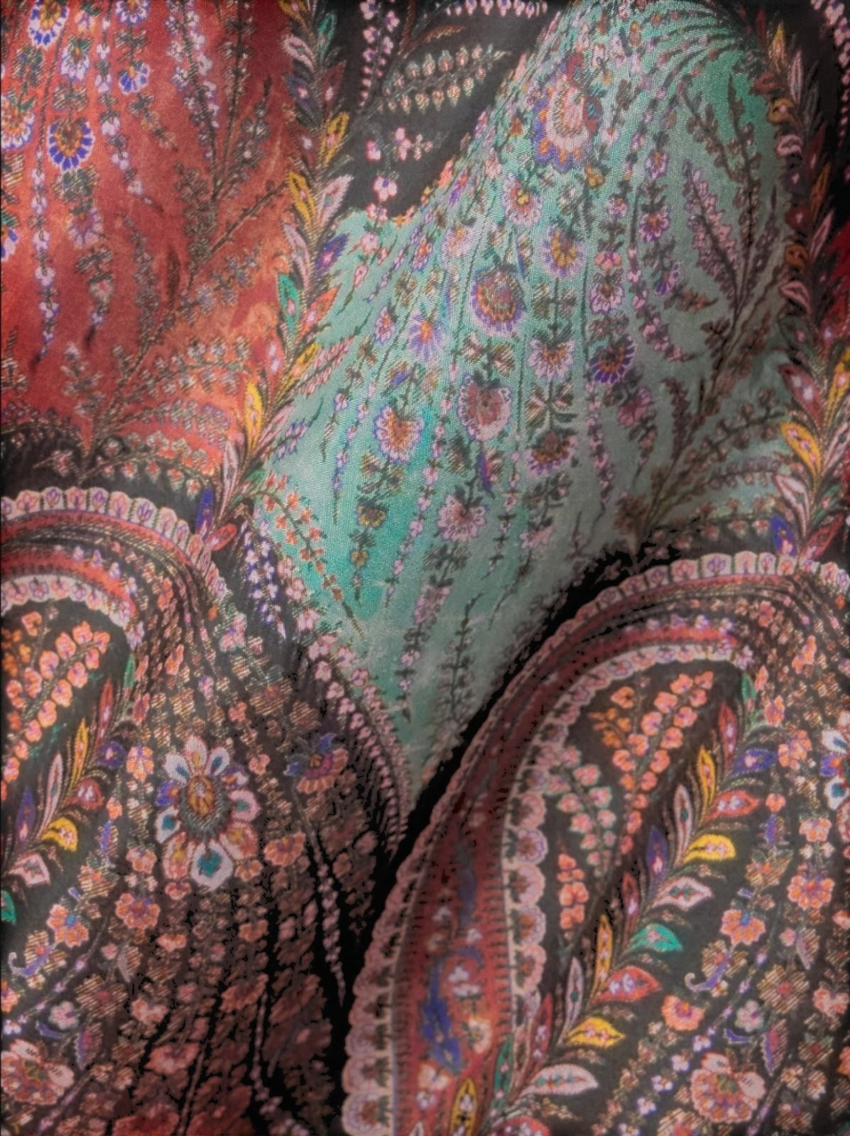 Close-up of the Naked Pear Zimmermann Rhiannon silk maxi skirt featuring a vibrant black paisley print with ruffles.